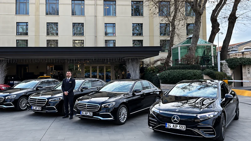 İstanbul'da bir otelin önünde takım elbiseli bir şoför ve siyah Mercedes S-Class, E-Class ve EQS araçlar